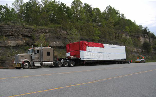 Truck hauling flatbed trailer loaded down.